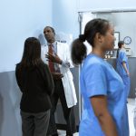 Profissionais de saúde conversam em um corredor de hospital.