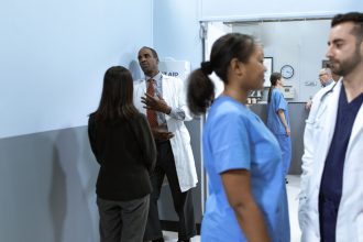 Profissionais de saúde conversam em um corredor de hospital.