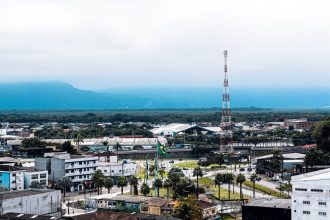 Vista aérea da área urbana de Praia Grande, com bairros residenciais e áreas verdes ao redor.