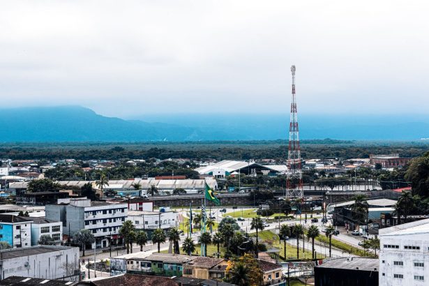 Vista aérea da área urbana de Praia Grande, com bairros residenciais e áreas verdes ao redor.