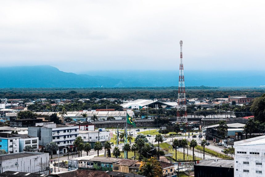 Vista aérea da área urbana de Praia Grande, com bairros residenciais e áreas verdes ao redor.