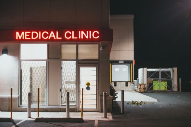 Entrada de uma clínica médica iluminada durante a noite, sem pessoas visíveis.